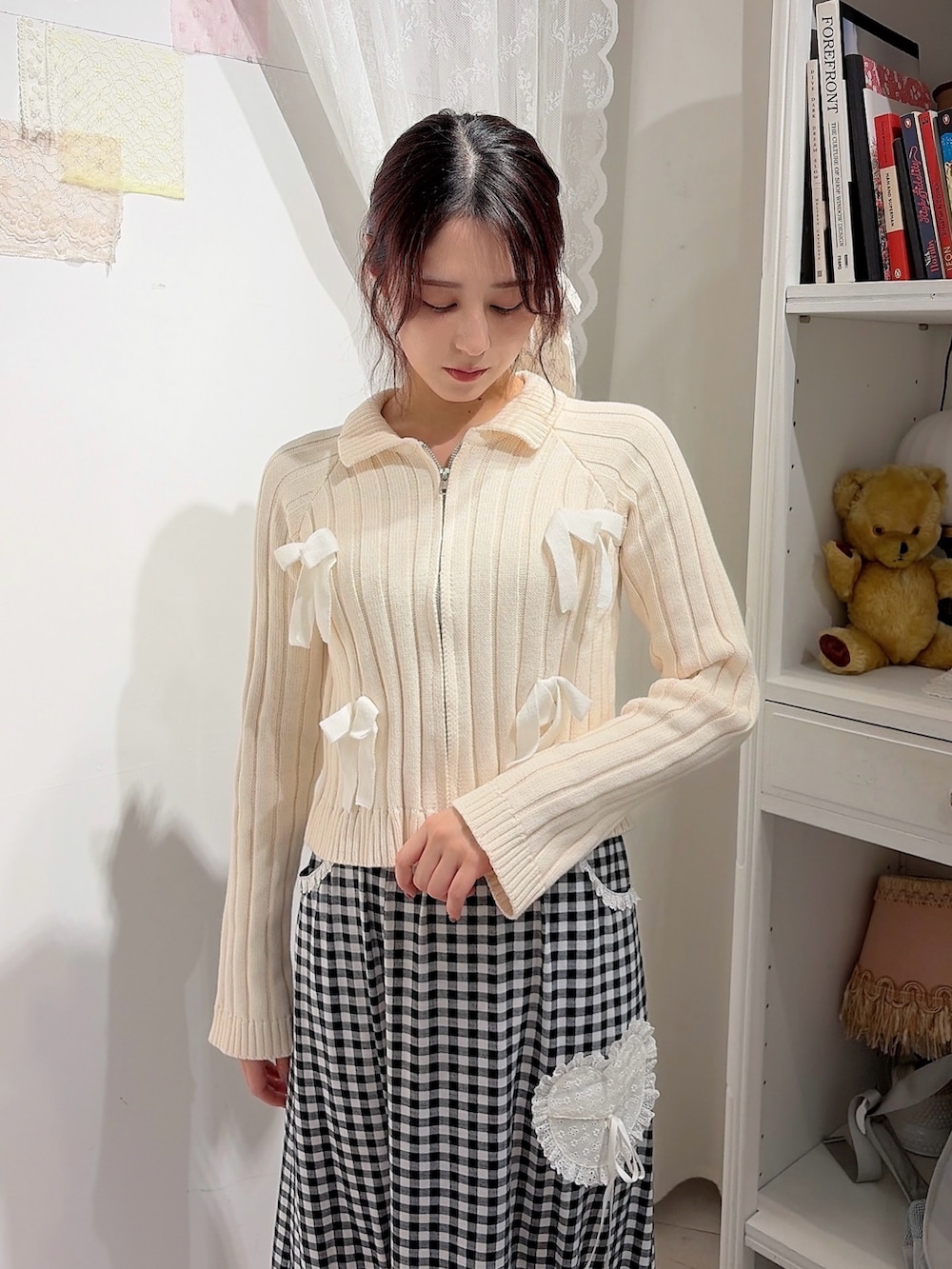 ホワイト系のカーディガン/ボレロ、ブラック系のスカート、ブラック系のスニーカーを着用したレディースの冬コーディネートの3枚目の写真