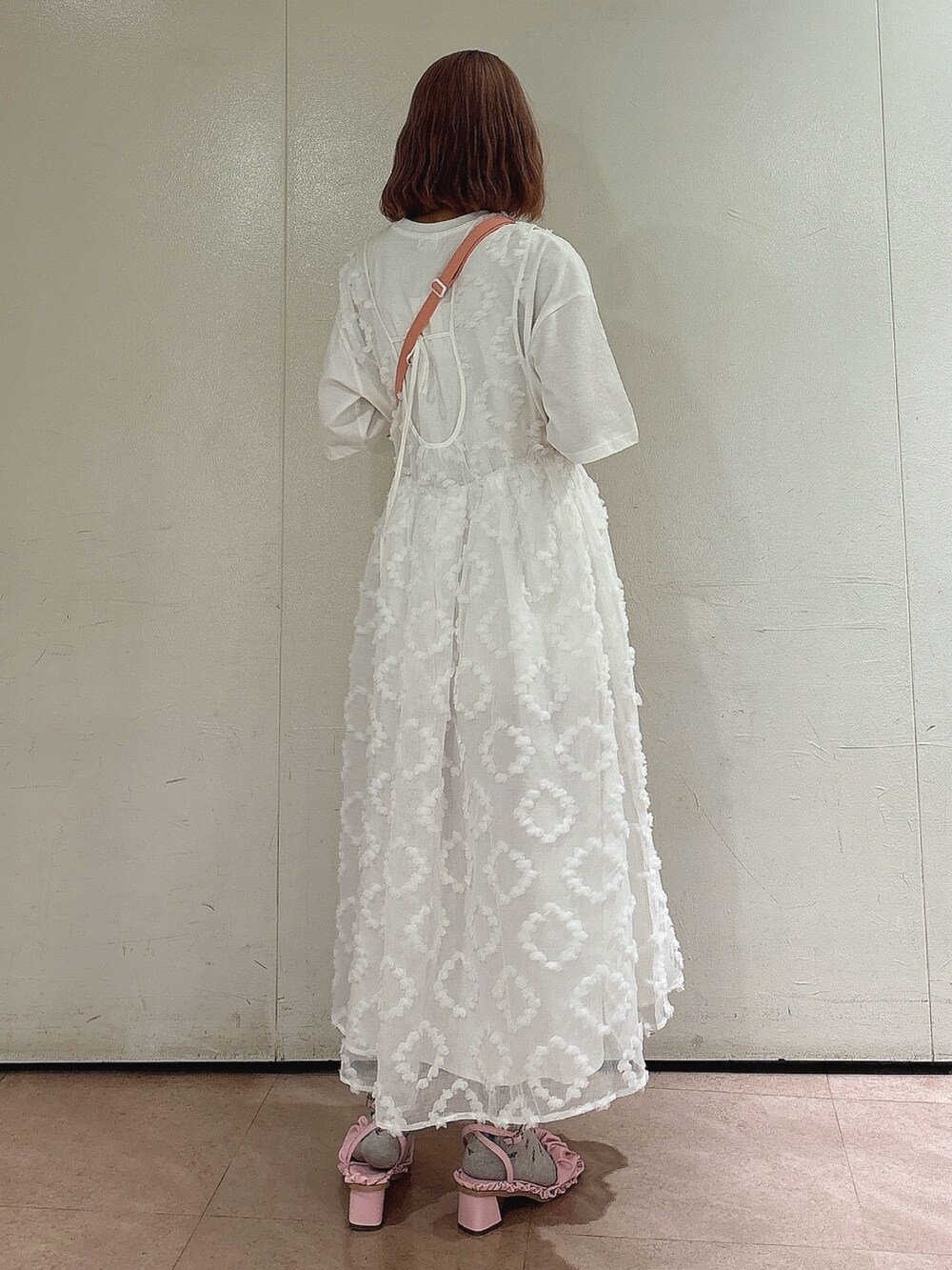 ピンク系のショルダーバッグ、ホワイト系のジャンパースカート、ホワイト系のTシャツ/カットソーを着用したレディースの夏コーディネートの2枚目の写真