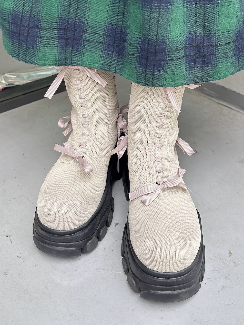 ホワイト系のニット/セーター、ホワイト系のショルダーバッグ、グリーン系のスカートを着用したレディースの秋コーディネートの8枚目の写真