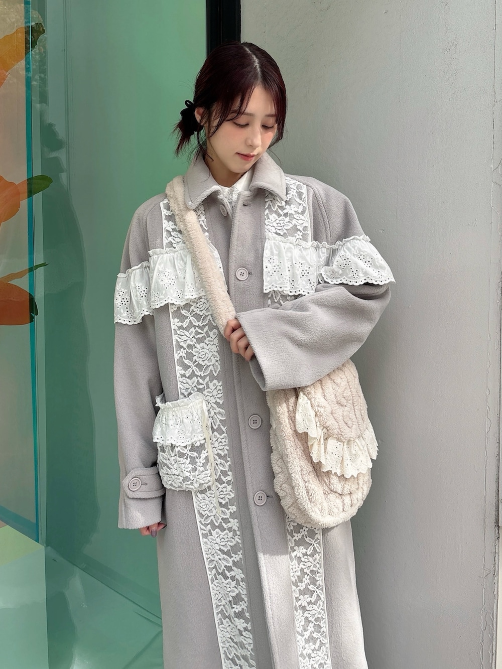 グレー系のチェスターコート、ベージュ系のショルダーバッグ、ホワイト系のワンピースを着用したレディースの秋コーディネートの3枚目の写真