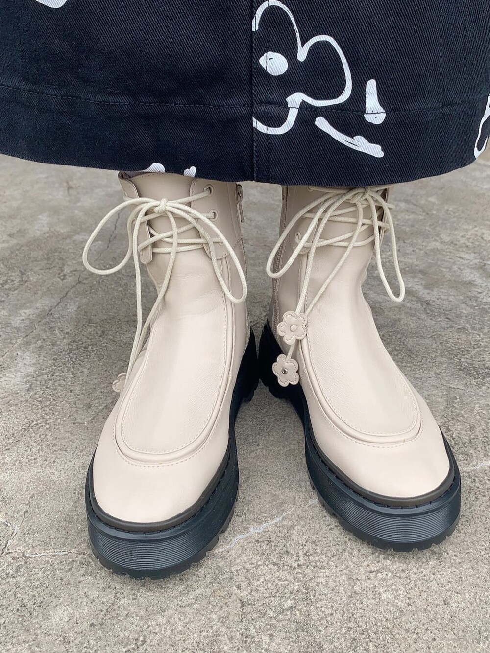 ブラック系のテーラードジャケット、ブルー系のニット/セーター、ホワイト系のブーツを着用したレディースの秋コーディネートの3枚目の写真