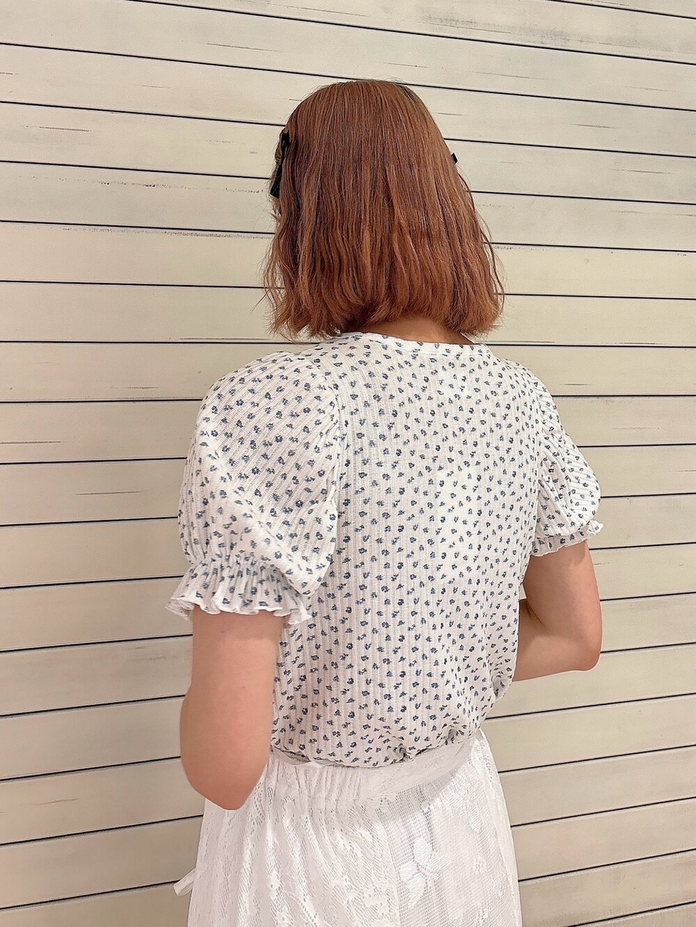 ホワイト系のスカート、ホワイト系のスニーカー、ブルー系のTシャツ/カットソーを着用したレディースの春コーディネートの4枚目の写真