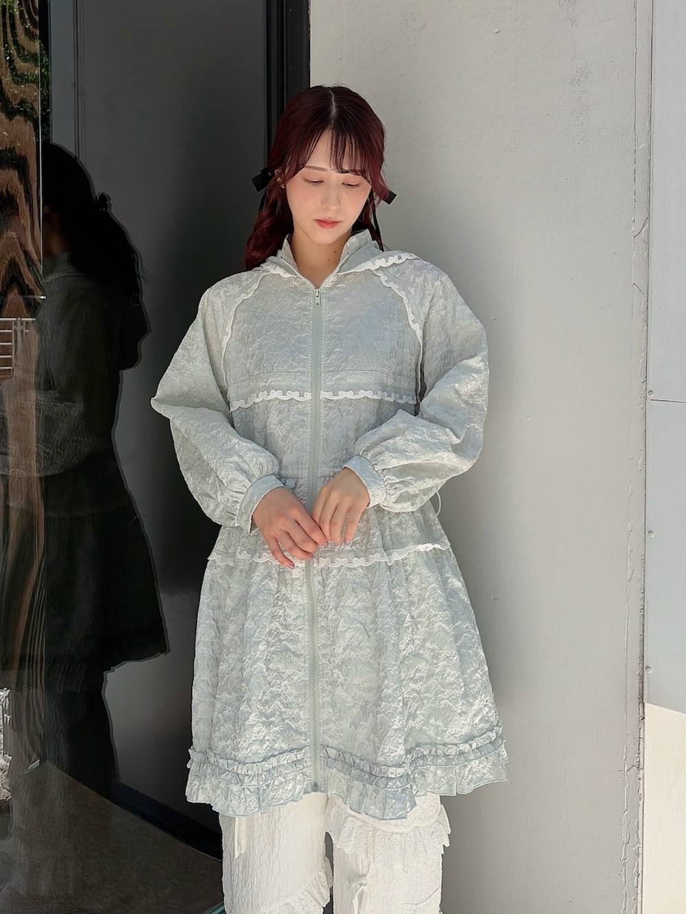グリーン系のワンピース、ホワイト系のカーゴパンツ、ピンク系のスニーカーを着用したレディースの春コーディネートの3枚目の写真