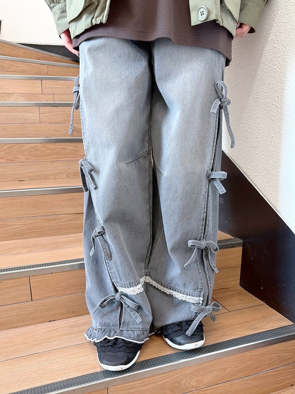 グリーン系のミリタリージャケット、ブラウン系のTシャツ/カットソー、グレー系のデニムパンツを着用したレディースの秋コーディネートの8枚目の写真