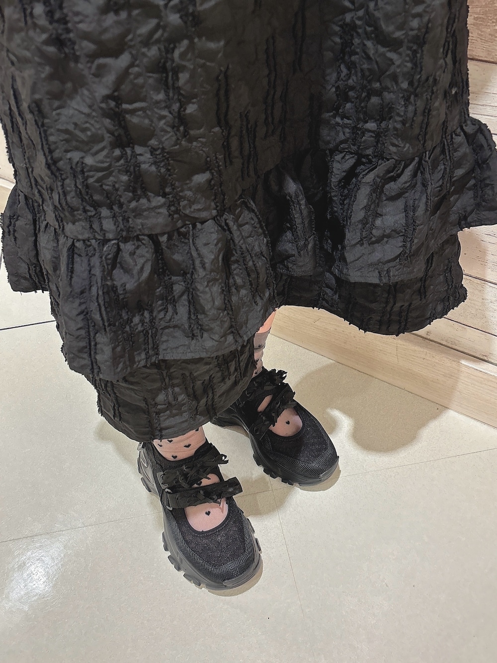 ブラック系のワンピース、シルバー系のショルダーバッグ、グレー系のTシャツ/カットソーを着用したレディースの春コーディネートの6枚目の写真