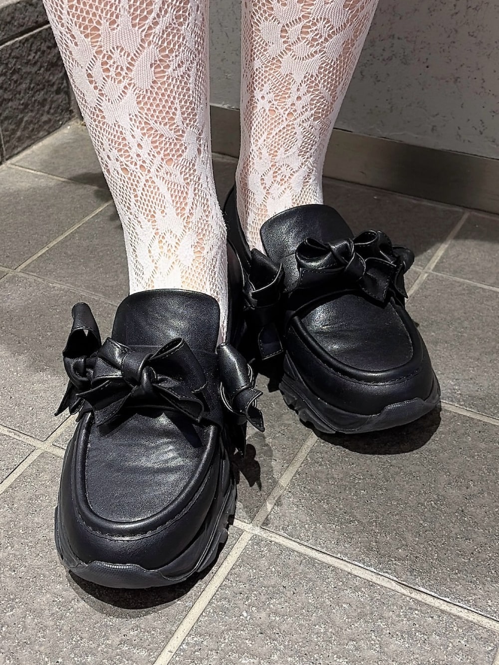 ホワイト系のスウェット、ブルー系のスカート、ブラック系のスニーカーを着用したレディースの冬コーディネートの7枚目の写真