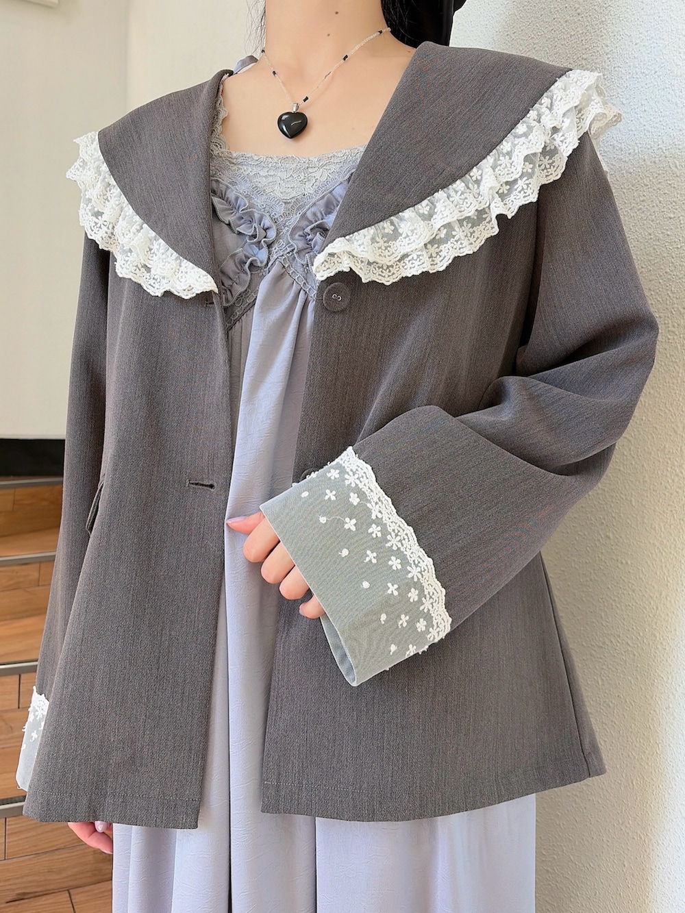 ブルー系のワンピース、ブラック系のパンプス、グレー系のテーラードジャケットを着用したレディースの春コーディネートの5枚目の写真