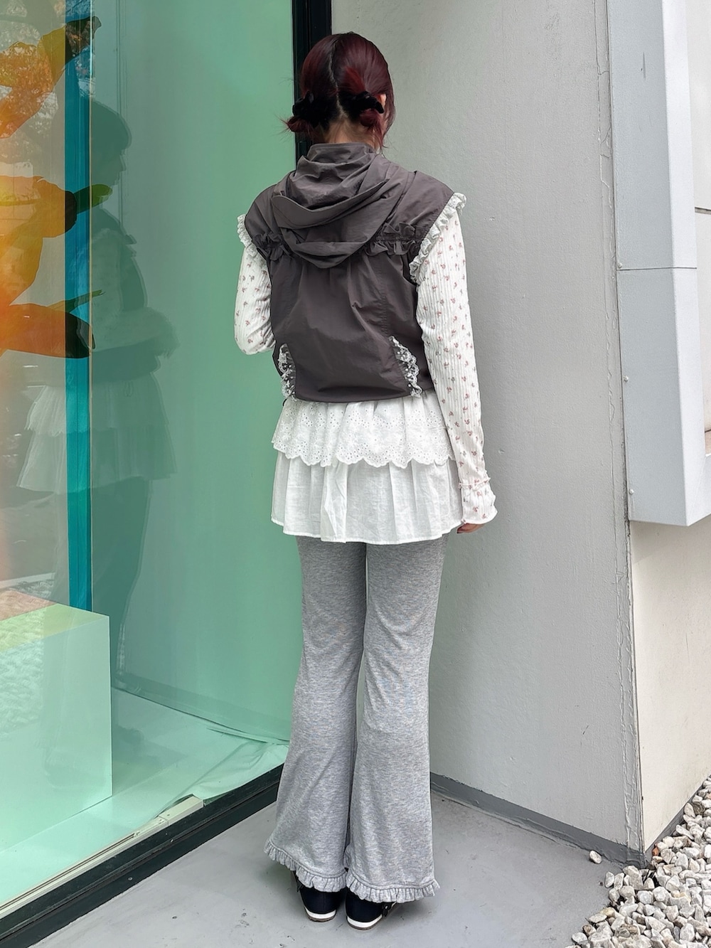 グレー系のベスト、ピンク系のTシャツ/カットソー、グレー系のスウェットパンツを着用したレディースの秋コーディネートの2枚目の写真