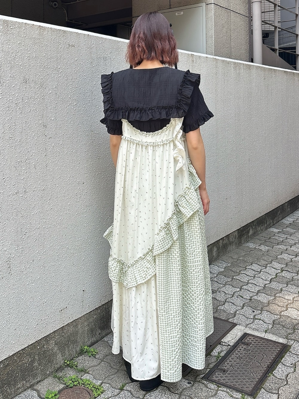 ブラック系のシャツ/ブラウス、グリーン系のワンピース、ブラック系のスニーカーを着用したレディースの春コーディネートの2枚目の写真