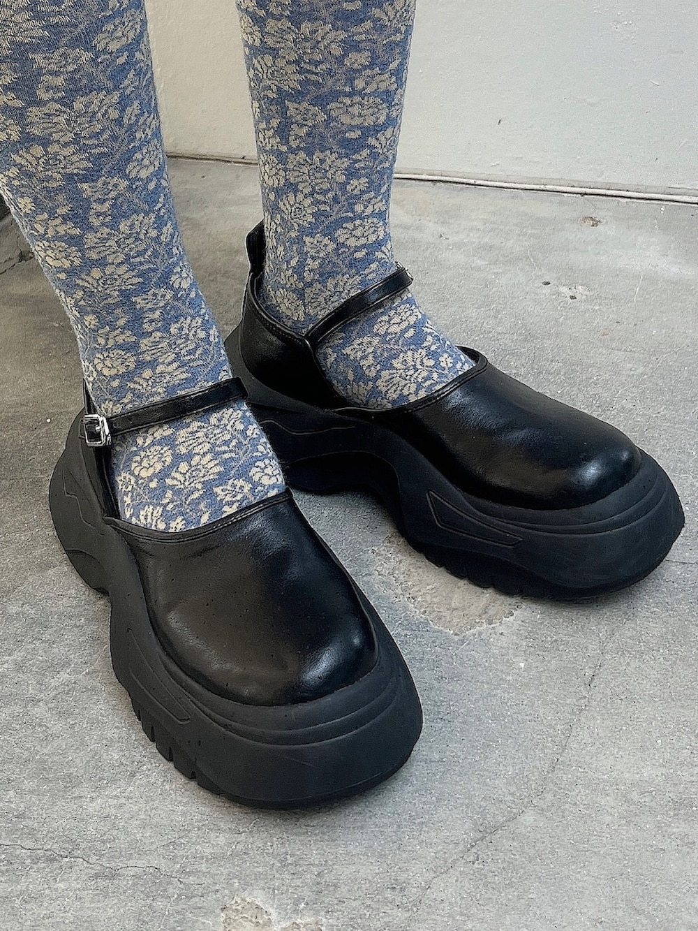 ブラック系のジャンパースカート、ブルー系のシャツ/ブラウス、ブラック系のスニーカーを着用したレディースの夏コーディネートの3枚目の写真