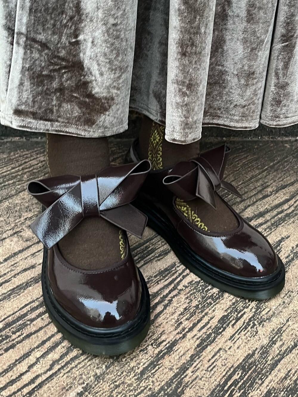 ブラウン系のスカート、ブラウン系のその他シューズ、イエロー系のマウンテンパーカーを着用したレディースの秋コーディネートの3枚目の写真