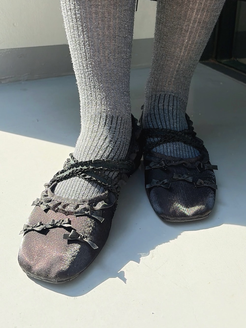 ブラック系のワンピース、ブラック系のカーディガン/ボレロ、ブラック系のバレエシューズを着用したレディースの春コーディネートの7枚目の写真