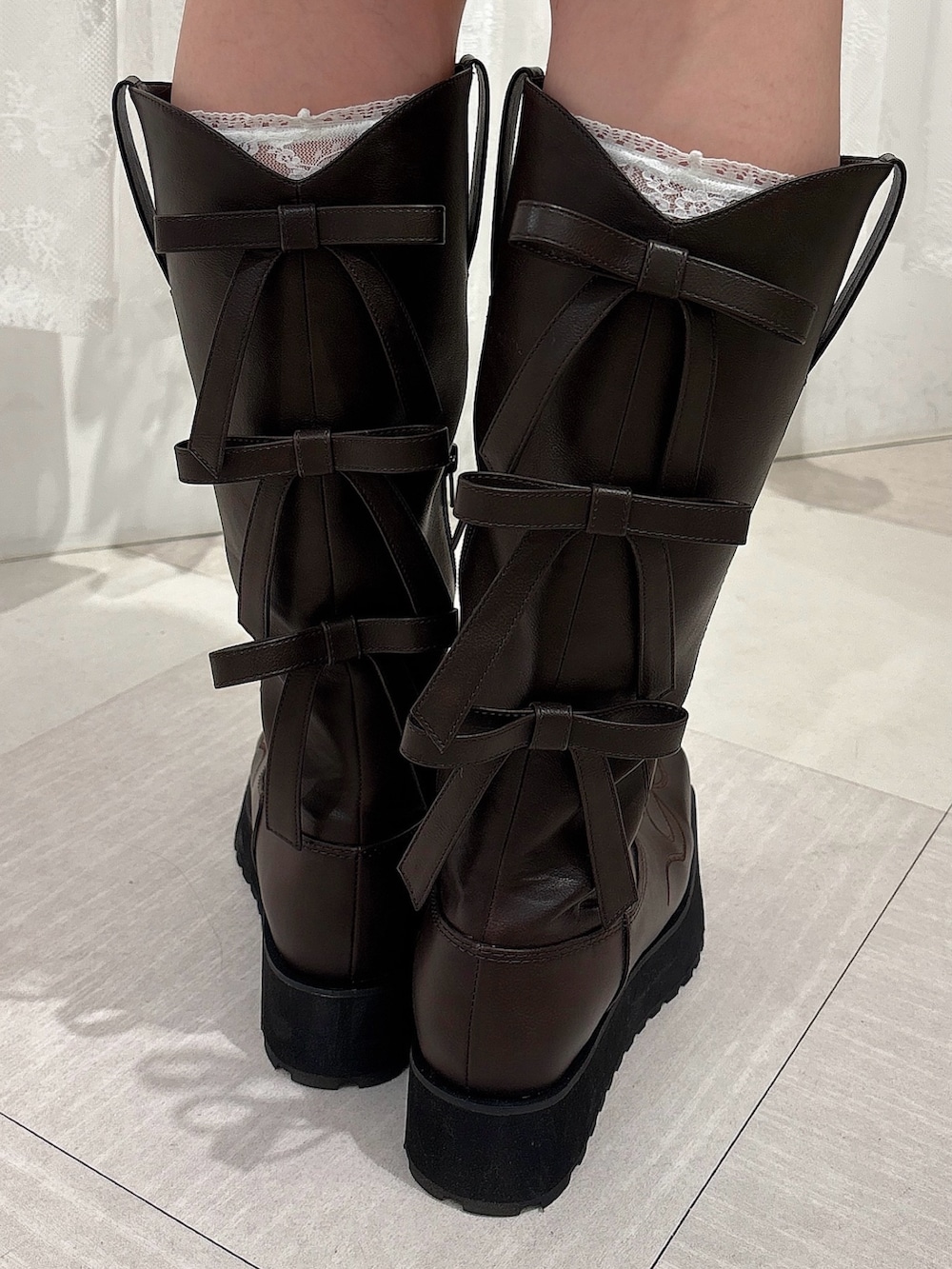 ブラウン系のスカート、ブラウン系のブーツ、グレー系のカーディガン/ボレロを着用したレディースの夏コーディネートの7枚目の写真