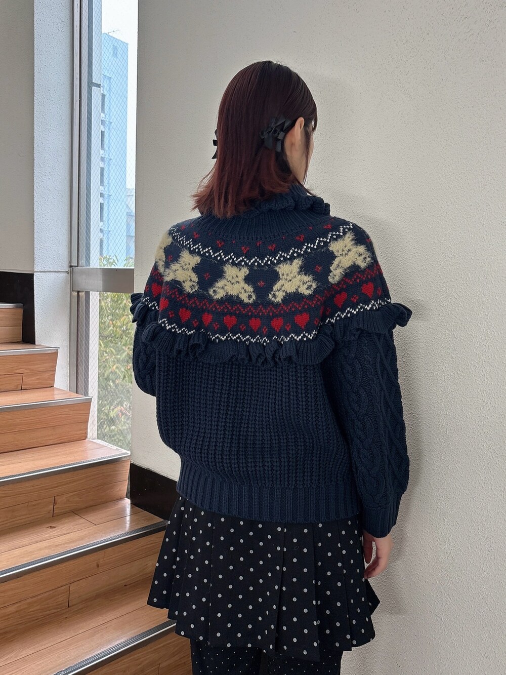 ブルー系のニット/セーター、ブラック系のスラックス、ブラック系のスカートを着用したレディースの秋コーディネートの4枚目の写真