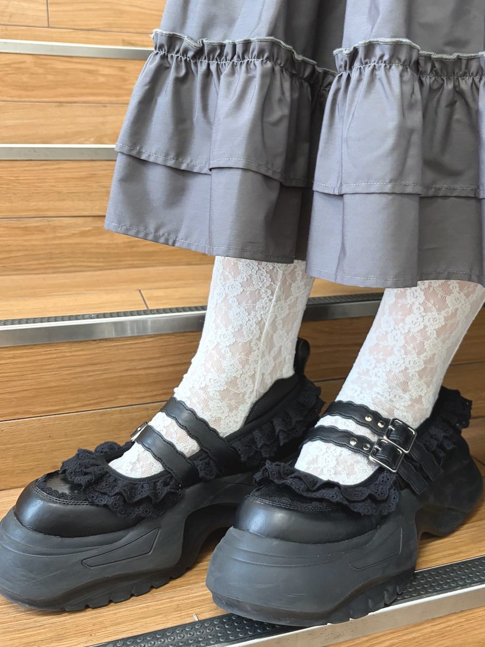 ブルー系のシャツ/ブラウス、グレー系のスカート、ブラック系のスニーカーを着用したレディースの夏コーディネートの7枚目の写真