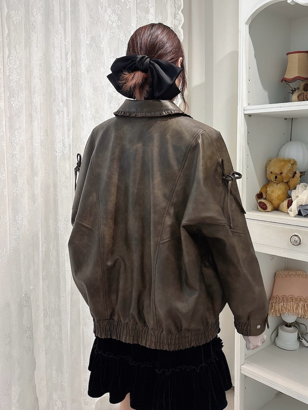 ブラック系のワンピース、ブラウン系のブルゾン、ベージュ系のTシャツ/カットソーを着用したレディースの秋コーディネートの4枚目の写真