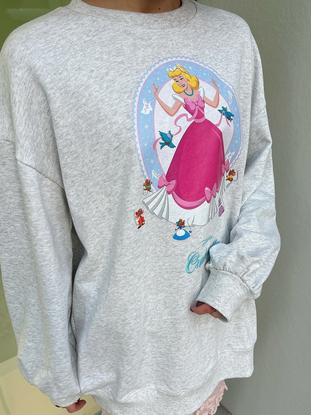 グレー系のスウェット、ホワイト系のスニーカー、ピンク系のレギンス/スパッツを着用したレディースの冬コーディネートの3枚目の写真