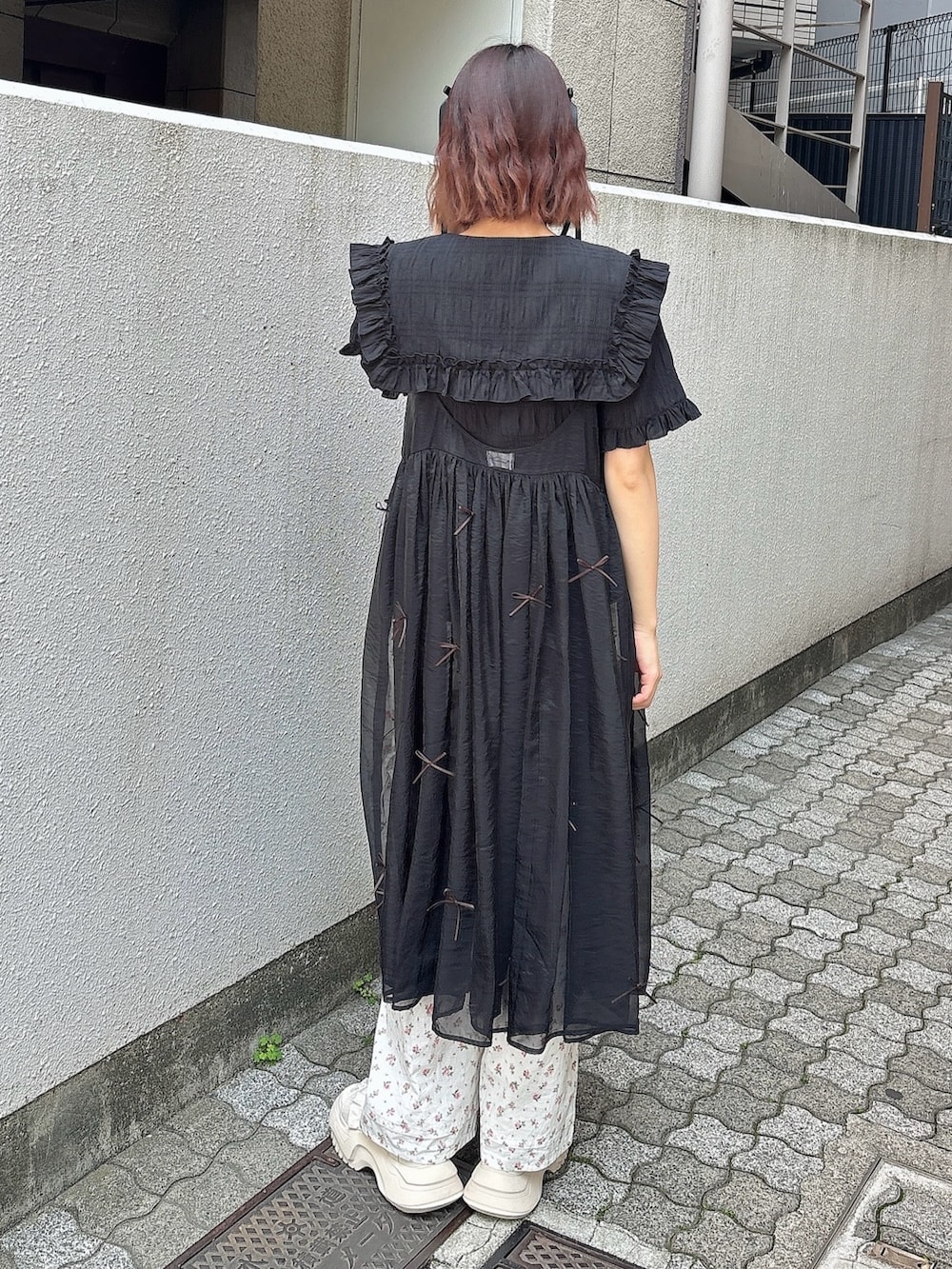 ブラック系のシャツ/ブラウス、ブラック系のワンピース、ホワイト系のスラックスを着用したレディースの春コーディネートの2枚目の写真