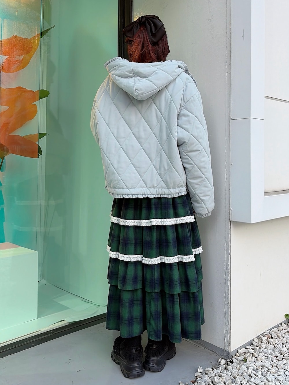 ブルー系のダウンジャケット/コート、ホワイト系のニット/セーター、グリーン系のスカートを着用したレディースの冬コーディネートの2枚目の写真