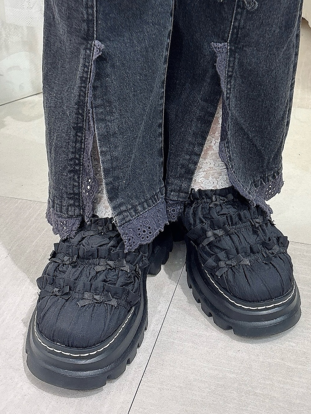 ブラック系のチュニック、ブラウン系のブルゾン、ホワイト系のTシャツ/カットソーを着用したレディースの夏コーディネートの7枚目の写真
