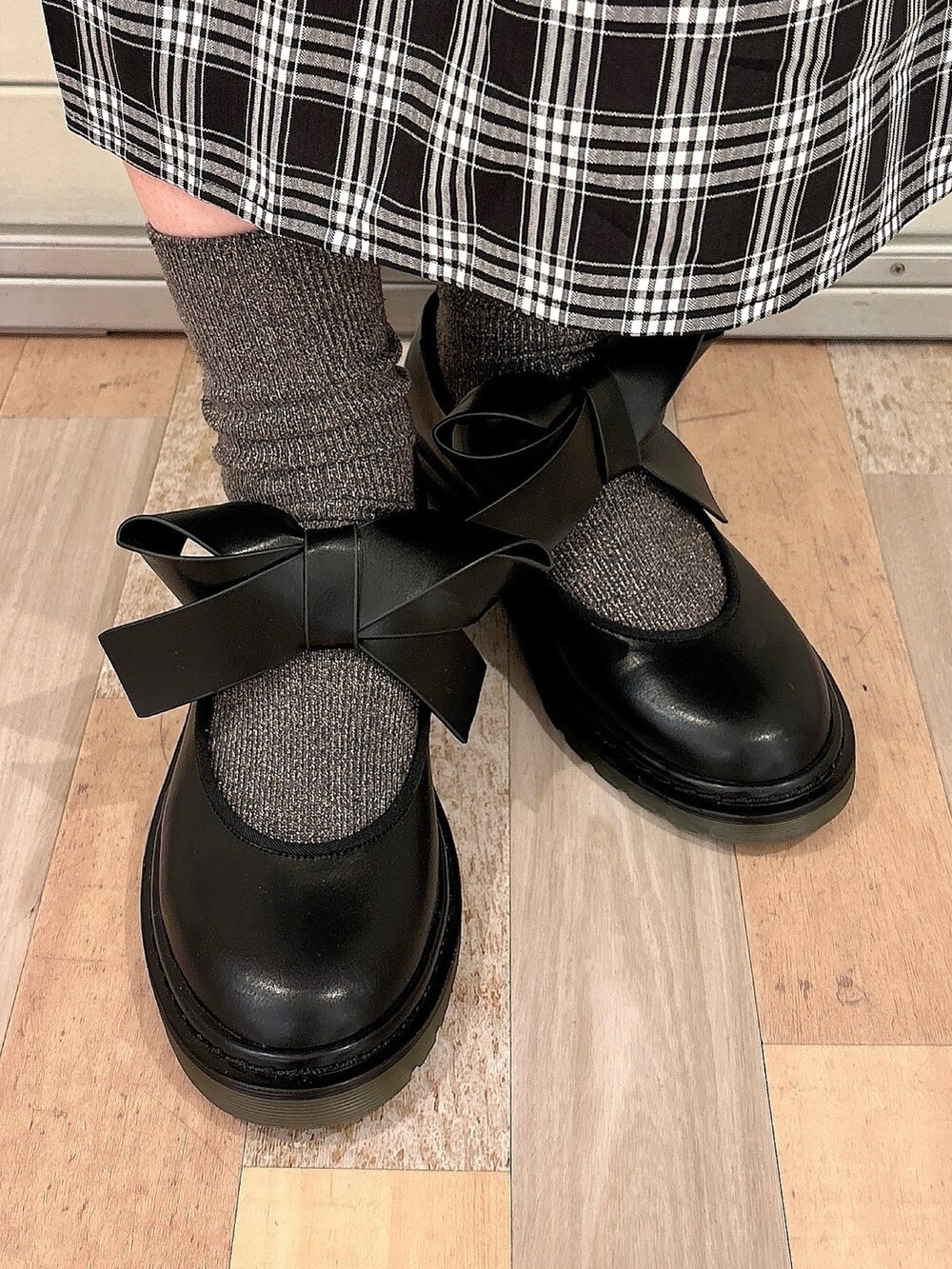 ブラック系のワンピース、ホワイト系のカーディガン/ボレロ、ブラック系のバレエシューズを着用したレディースの秋コーディネートの6枚目の写真