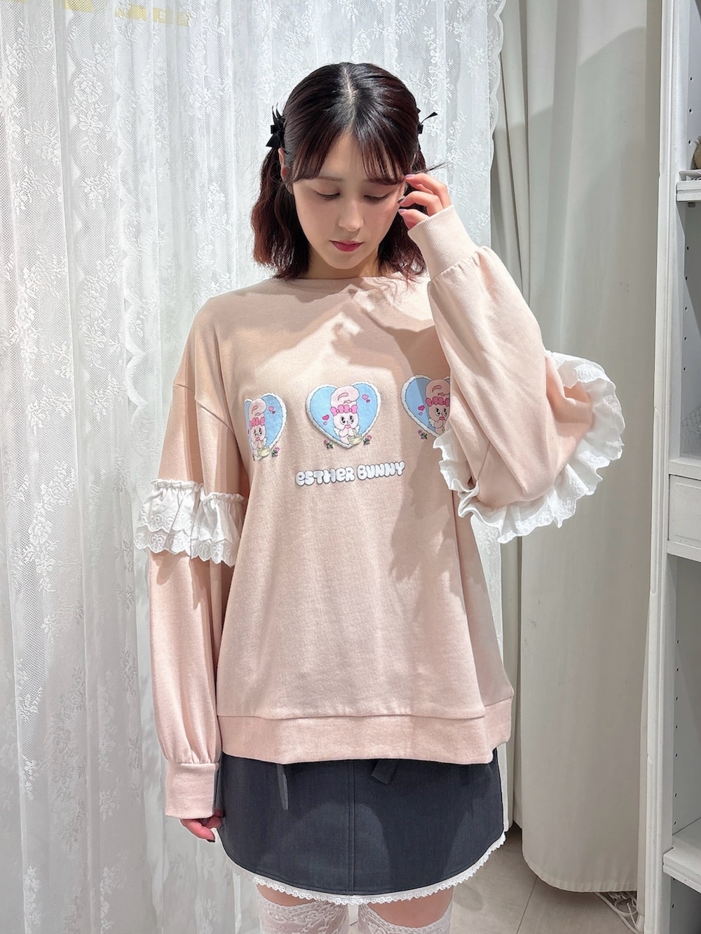 ピンク系のスウェット、グレー系のスカート、ホワイト系のスニーカーを着用したレディースの秋コーディネートの3枚目の写真