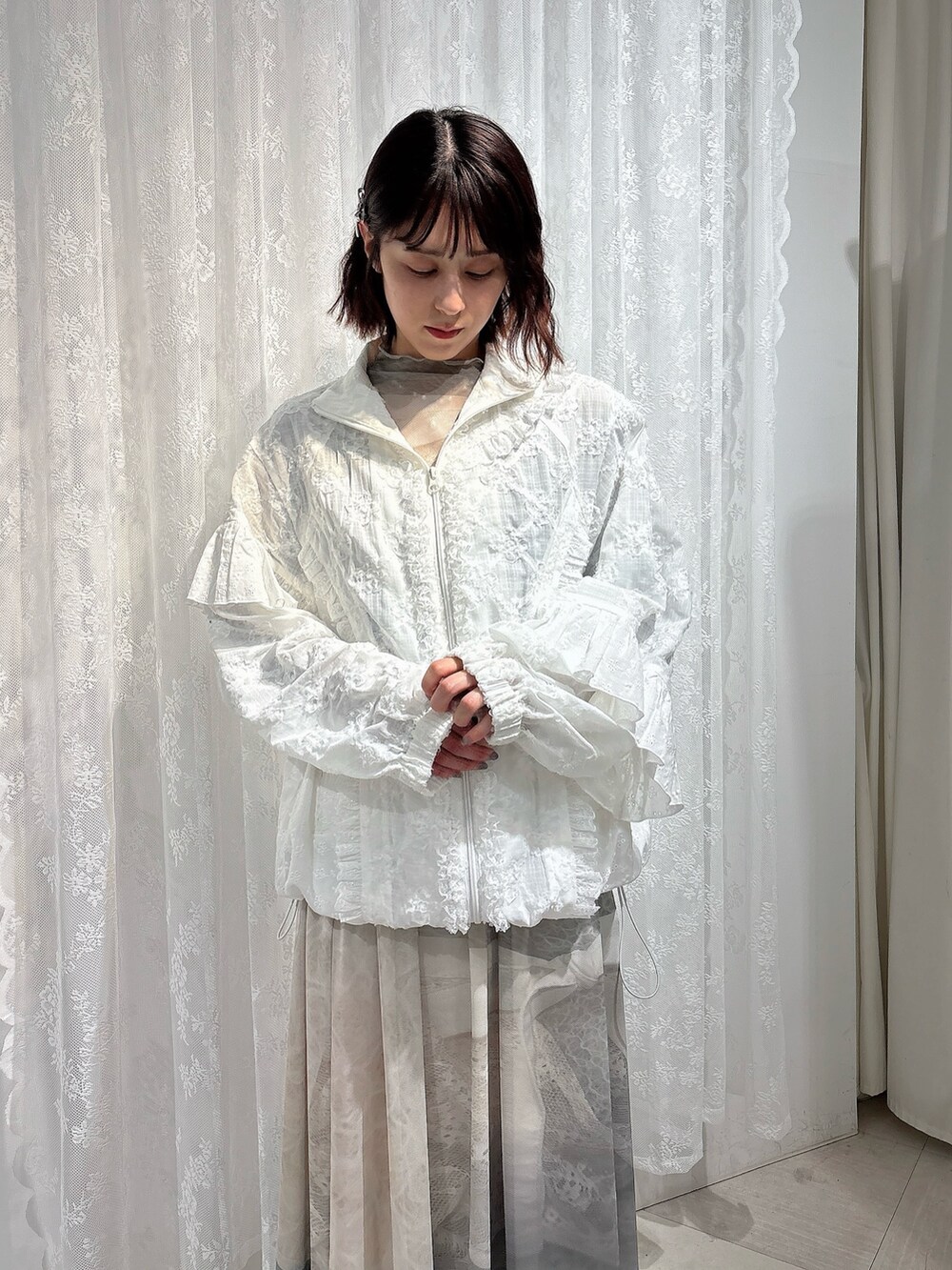 ホワイト系のブルゾン、グリーン系のTシャツ/カットソー、グリーン系のスカートを着用したレディースの春コーディネートの3枚目の写真