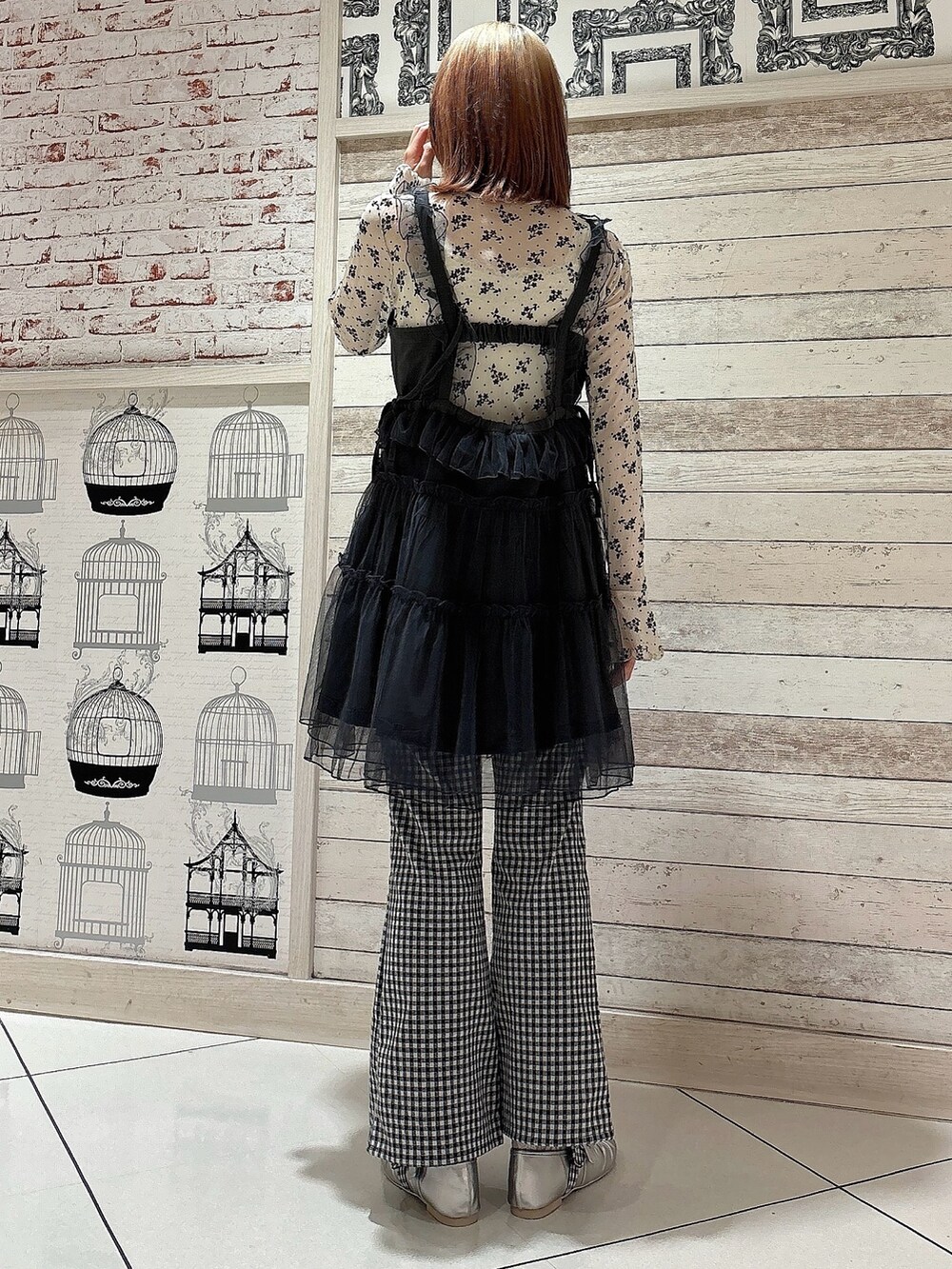 グレー系のワンピース、ホワイト系のTシャツ/カットソー、ブラック系のスラックスを着用したレディースの夏コーディネートの2枚目の写真