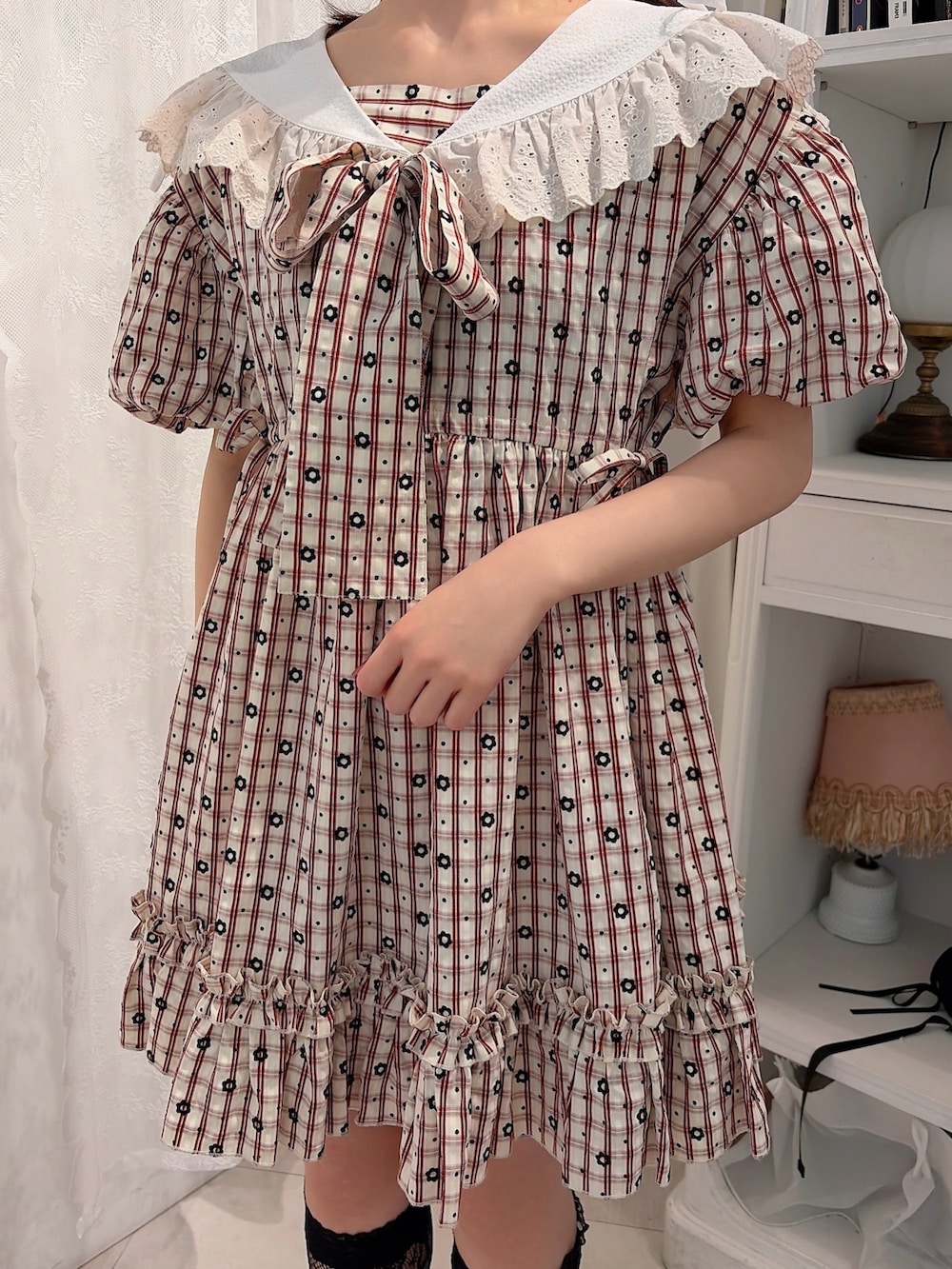 レッド系のワンピース、ブラック系のサンダルを着用したレディースの春コーディネートの5枚目の写真
