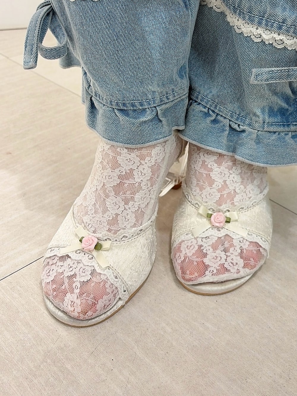 グレー系のワンピース、ホワイト系のキャミソール、ブルー系のデニムパンツを着用したレディースの春コーディネートの6枚目の写真