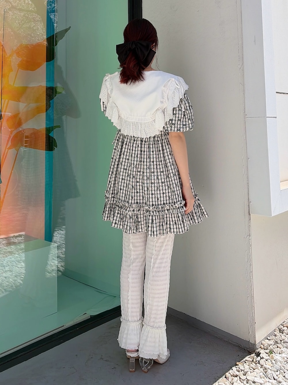 ブラック系のワンピース、ホワイト系のその他パンツ、ホワイト系のサンダルを着用したレディースの春コーディネートの2枚目の写真