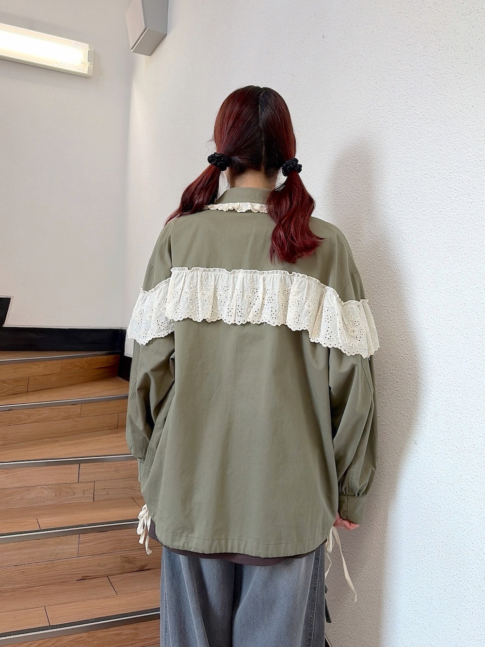 グリーン系のミリタリージャケット、ブラウン系のTシャツ/カットソー、グレー系のデニムパンツを着用したレディースの秋コーディネートの5枚目の写真
