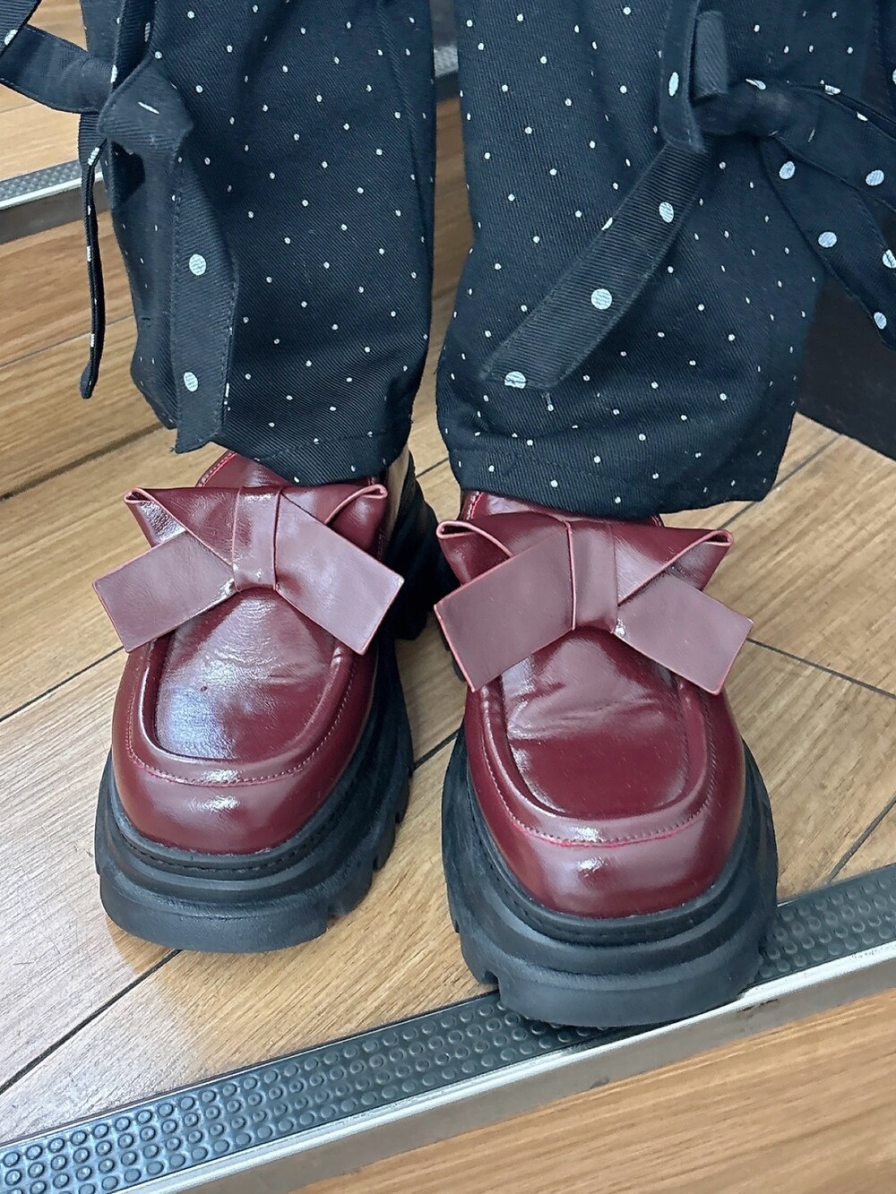 ブルー系のニット/セーター、ブラック系のスラックス、ブラック系のスカートを着用したレディースの秋コーディネートの7枚目の写真