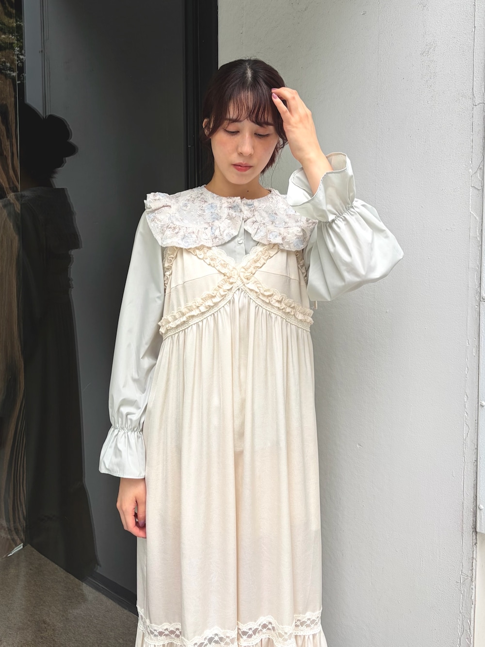 グリーン系のシャツ/ブラウス、ホワイト系のワンピース、ベージュ系のパンプスを着用したレディースの夏コーディネートの3枚目の写真