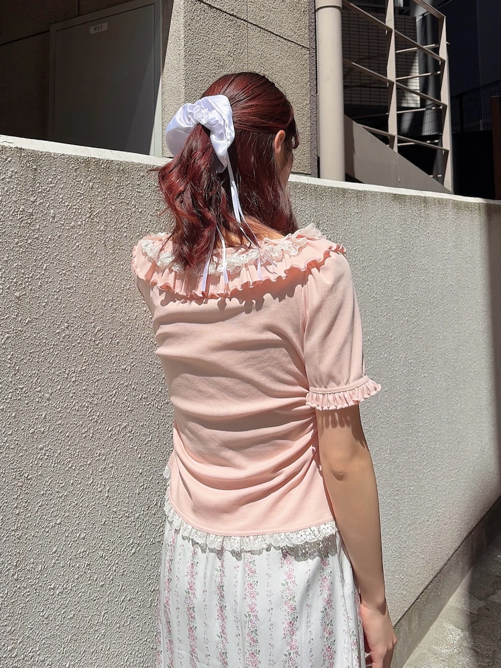 ピンク系のTシャツ/カットソー、ピンク系のスカート、ホワイト系のサンダルを着用したレディースの春コーディネートの4枚目の写真