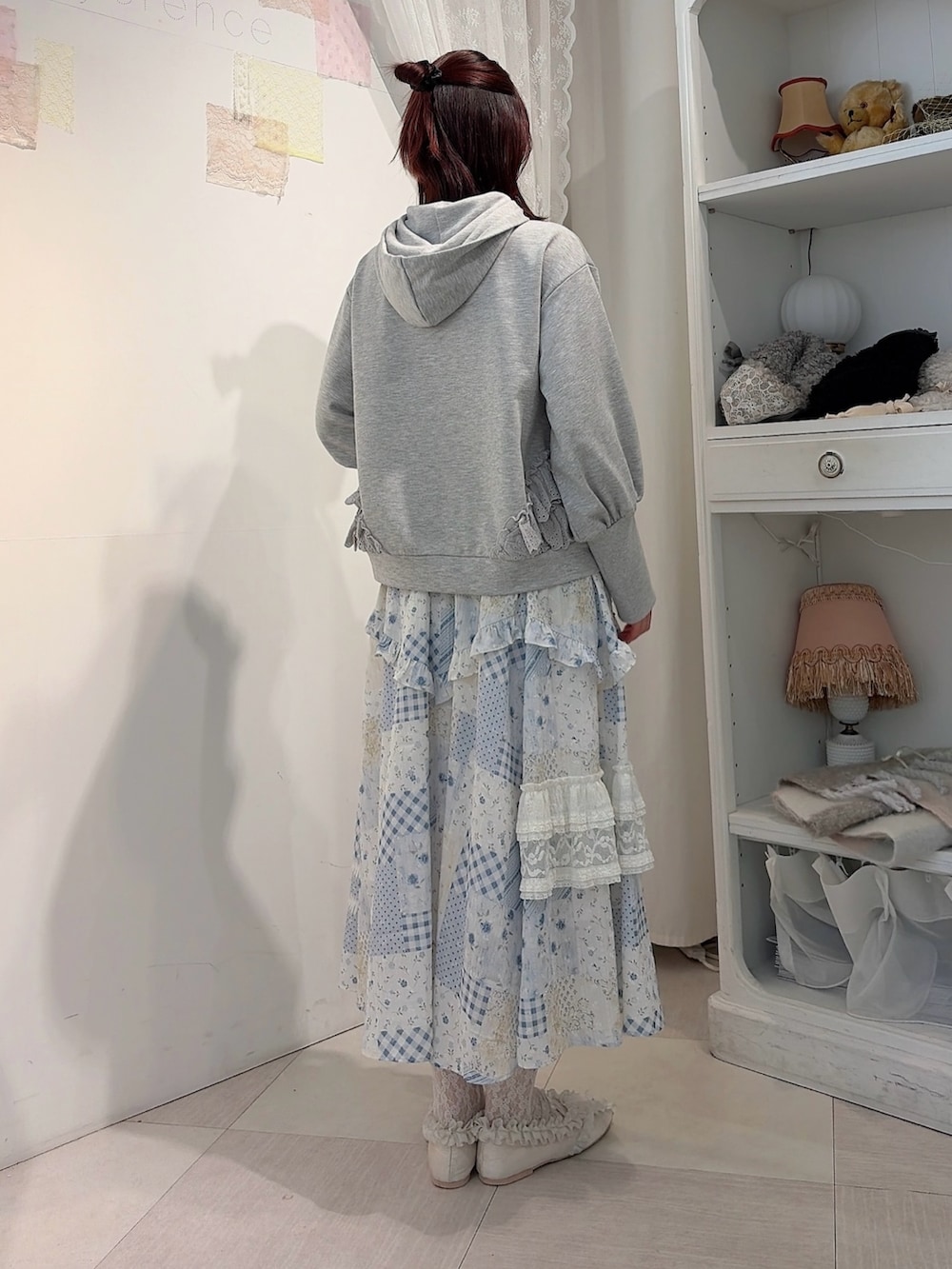 グレー系のパーカー、ブルー系のスカート、ホワイト系のバレエシューズを着用したレディースの冬コーディネートの2枚目の写真