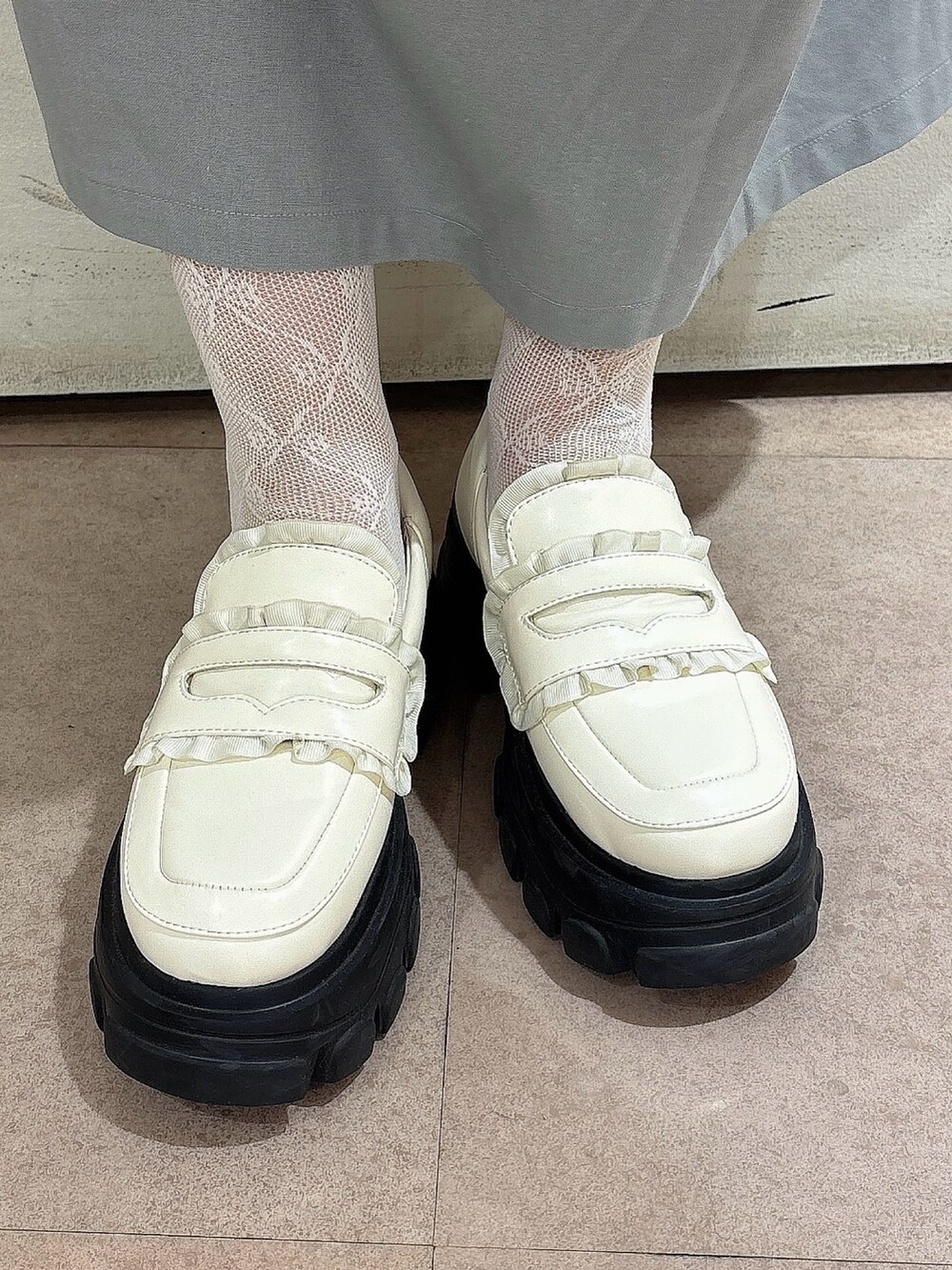 グレー系のワンピース、ホワイト系のTシャツ/カットソー、ホワイト系のローファーを着用したレディースの春コーディネートの6枚目の写真