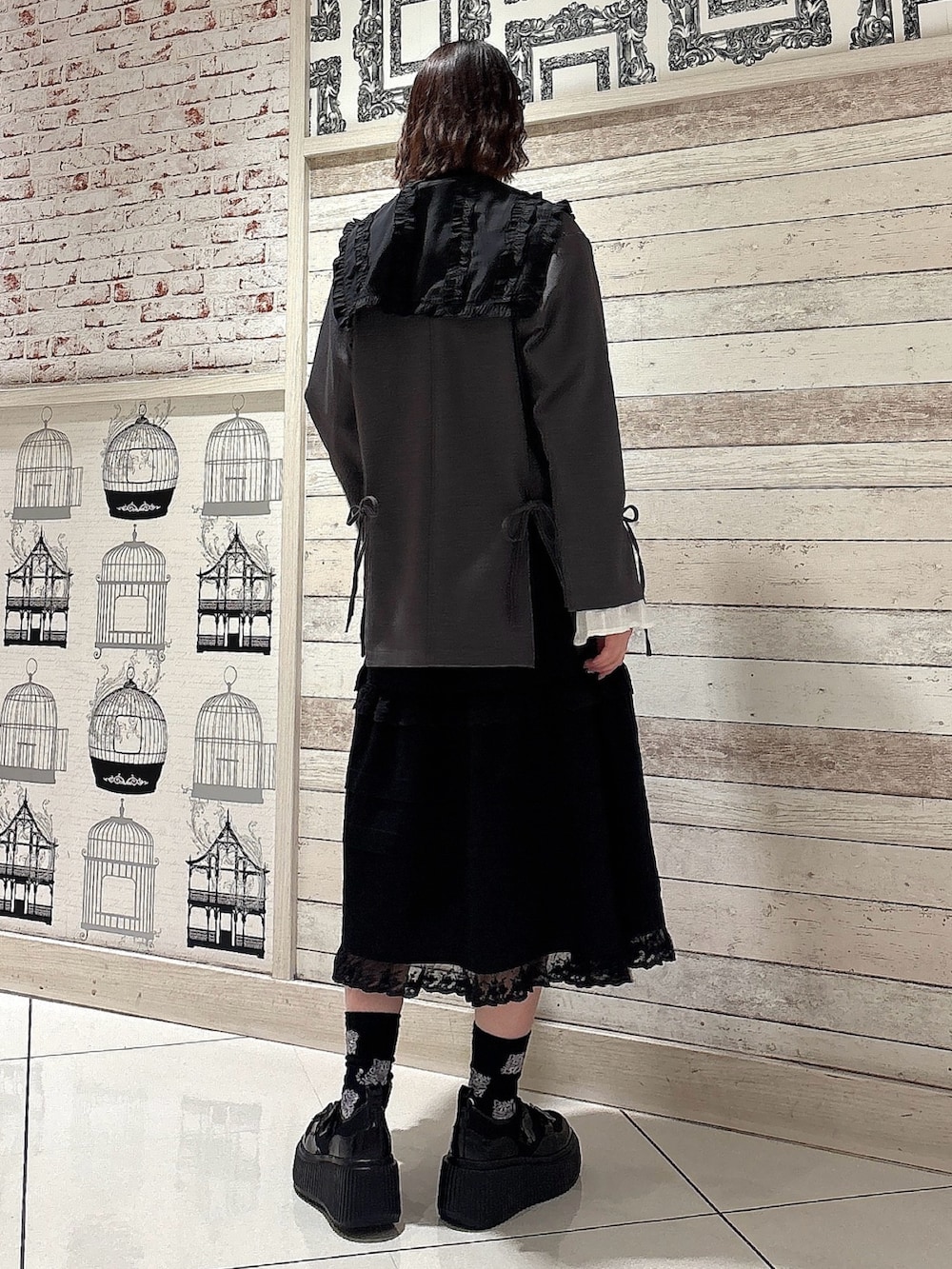 ブラック系のシャツ/ブラウス、グレー系のテーラードジャケット、ブラック系のスカートを着用したレディースの冬コーディネートの2枚目の写真