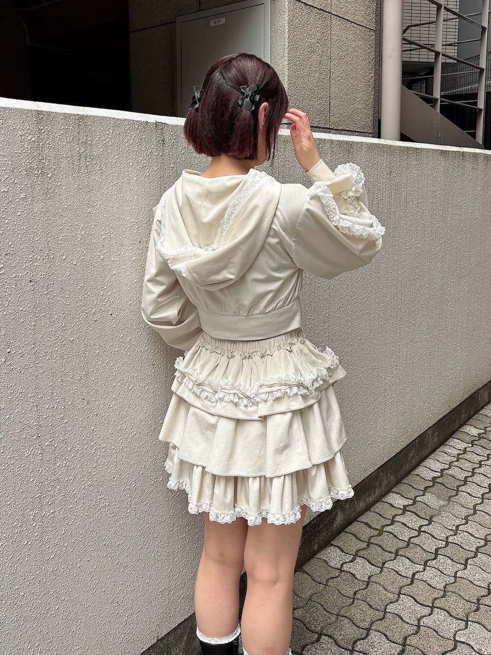 ホワイト系のパーカー、ホワイト系のスカート、ブラック系のブーツを着用したレディースの夏コーディネートの4枚目の写真