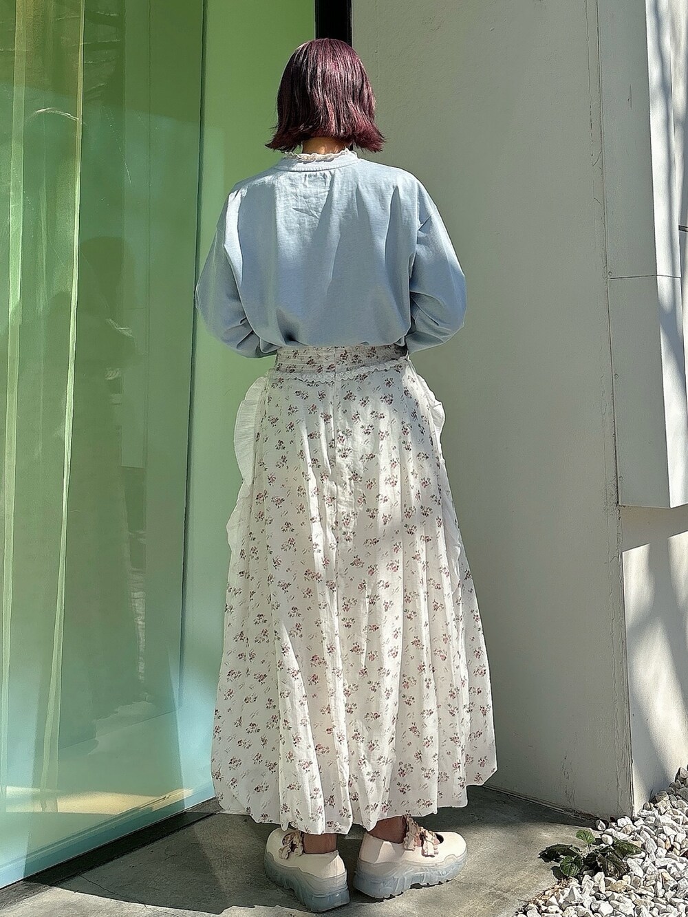ホワイト系のスカート、ホワイト系のスニーカー、ホワイト系のTシャツ/カットソーを着用したレディースの冬コーディネートの2枚目の写真
