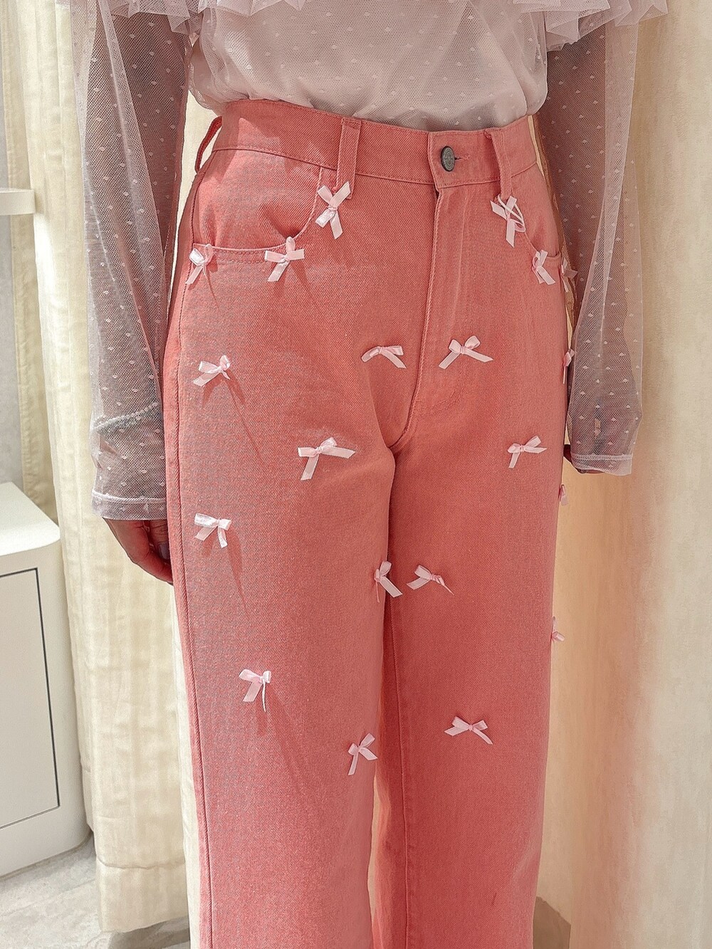 ピンク系のTシャツ/カットソー、ピンク系のデニムパンツ、ホワイト系のスニーカーを着用したレディースの夏コーディネートの6枚目の写真