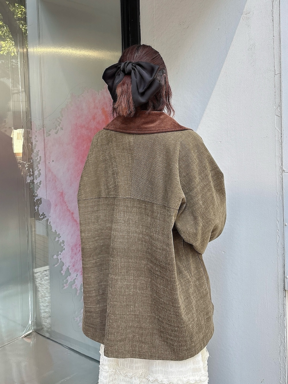 ホワイト系のスカート、ブラウン系のブルゾン、ベージュ系のTシャツ/カットソーを着用したレディースの夏コーディネートの4枚目の写真