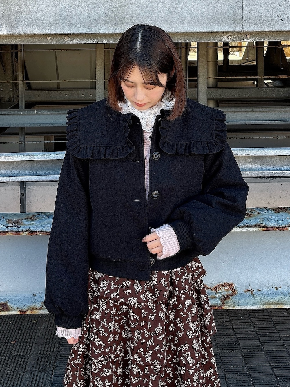 ブラウン系のワンピース、ブラック系のパンプス、ピンク系のカーディガン/ボレロを着用したレディースの冬コーディネートの3枚目の写真