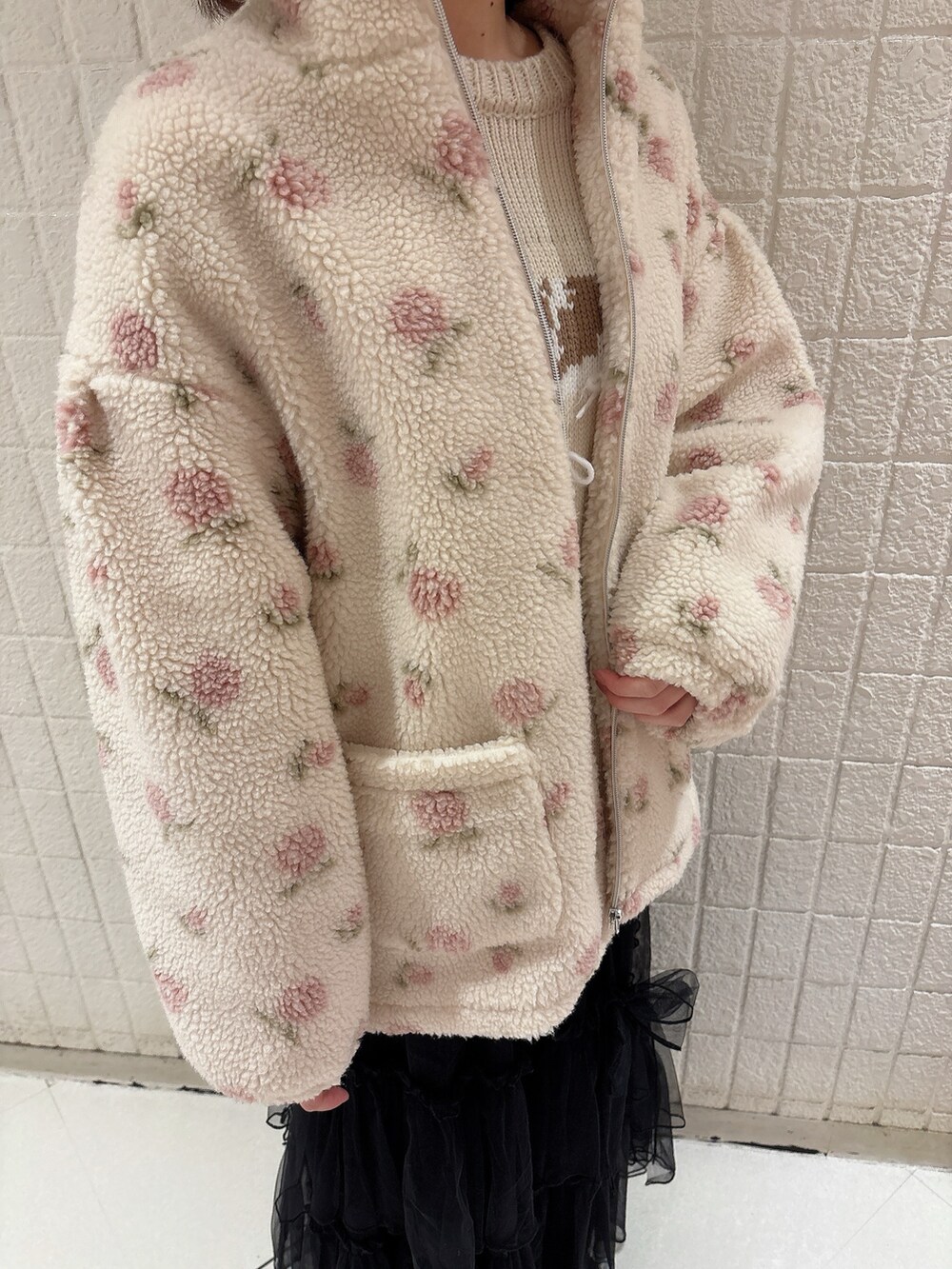 ピンク系のブルゾン、ホワイト系のニット/セーター、ブラック系のスカートを着用したレディースの冬コーディネートの5枚目の写真