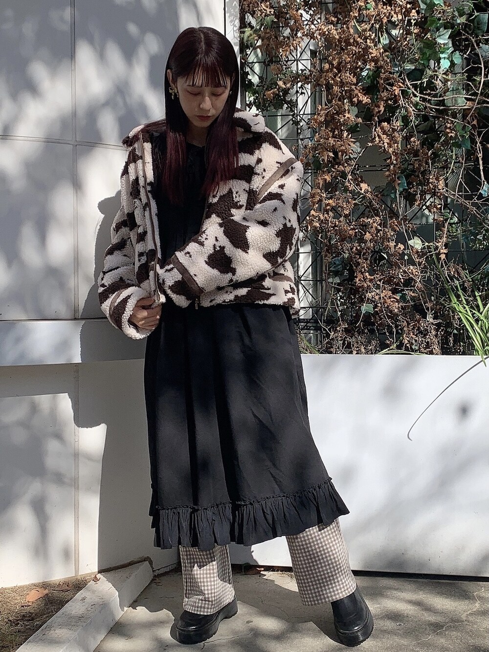 ブラウン系のその他アウター、ブラック系のブーツ、ブラック系のワンピースを着用したレディースの秋コーディネートの2枚目の写真