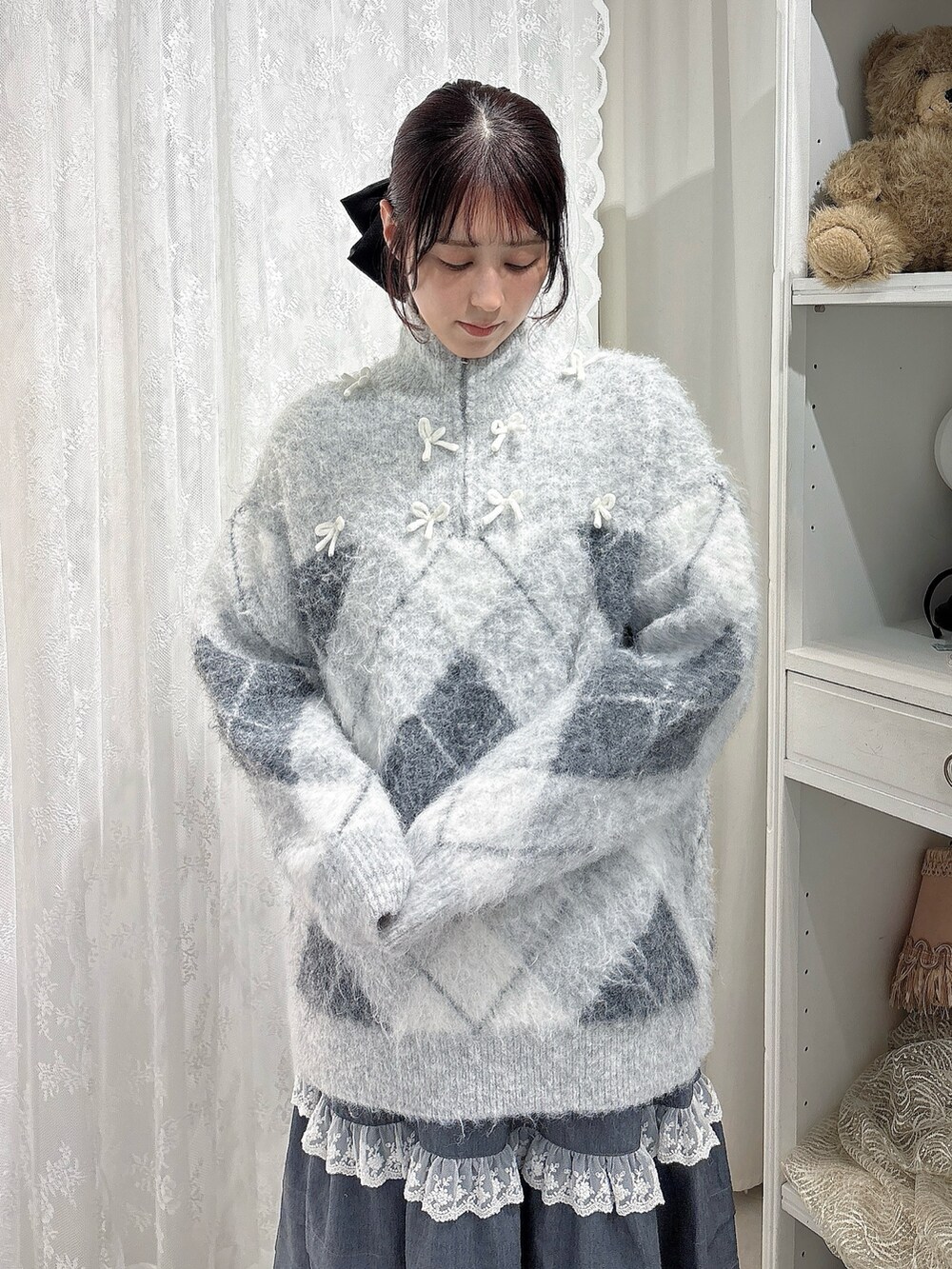 グレー系のニット/セーター、グレー系のスカート、ブラック系のブーツを着用したレディースの秋コーディネートの3枚目の写真