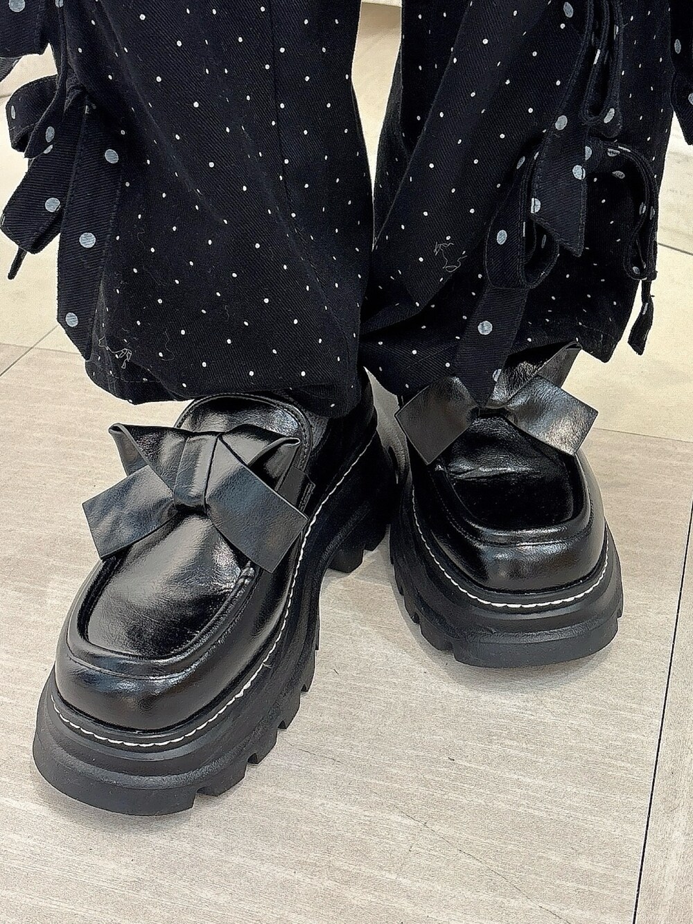 ブラウン系のムートンコート、パープル系のニット/セーター、ブラック系のスカートを着用したレディースの秋コーディネートの7枚目の写真