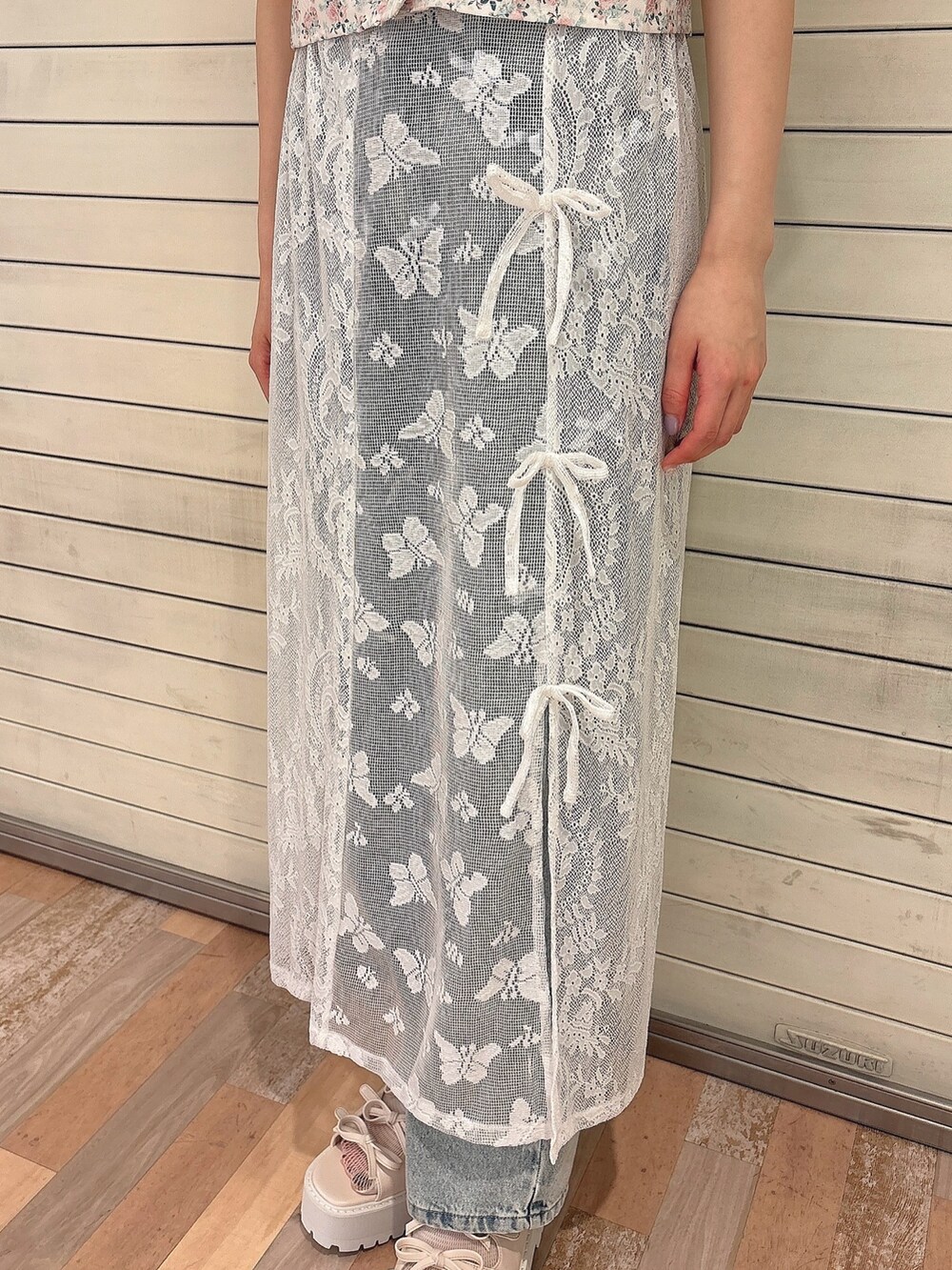 ピンク系のシャツ/ブラウス、ホワイト系のスカート、ブルー系のデニムパンツを着用したレディースの春コーディネートの6枚目の写真