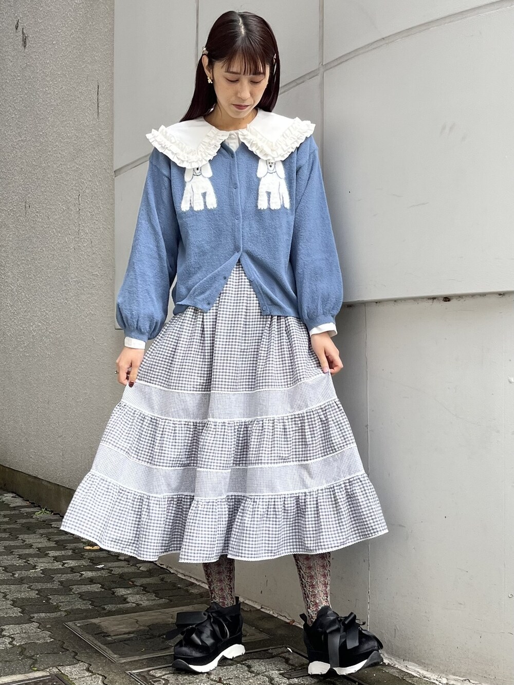 ブラック系のスニーカー、ホワイト系のシャツ/ブラウス、グレー系のスカートを着用したレディースの冬コーディネートの2枚目の写真