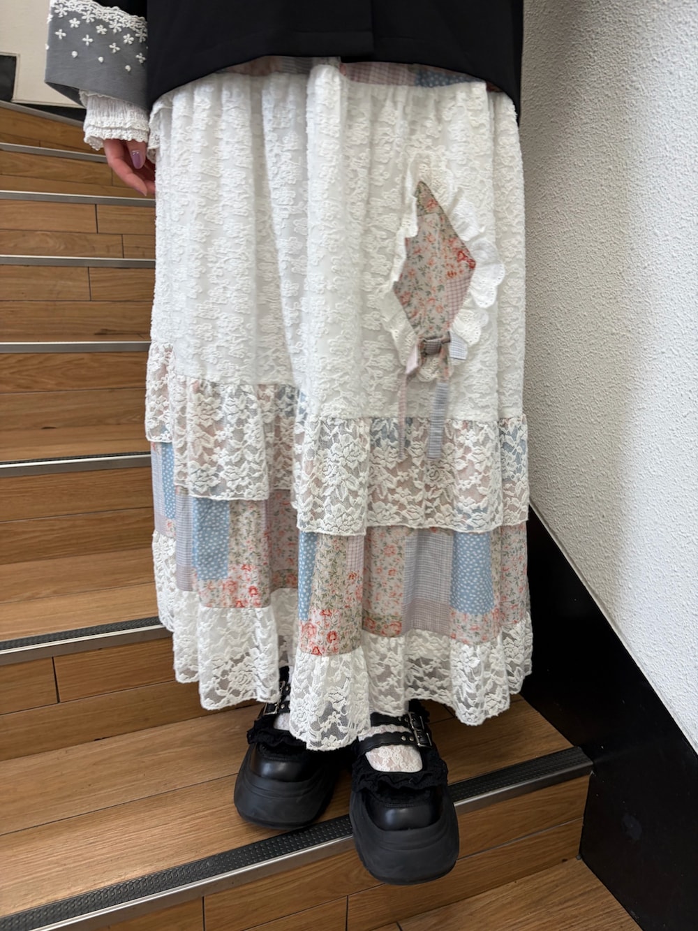 ピンク系のスカート、ブラック系のスニーカー、ブラック系のショルダーバッグを着用したレディースの夏コーディネートの7枚目の写真